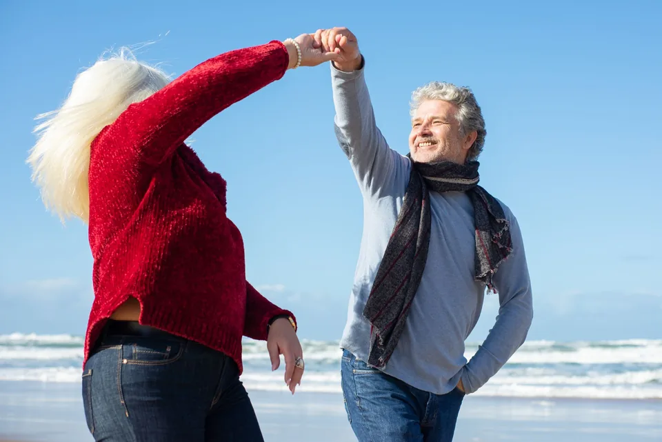 A couple walking hand in hand along the beach