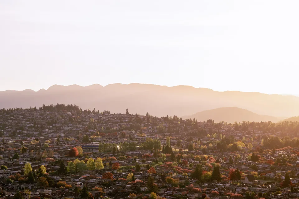 Suburban streets beneath soft layered mountains in sunset haze
